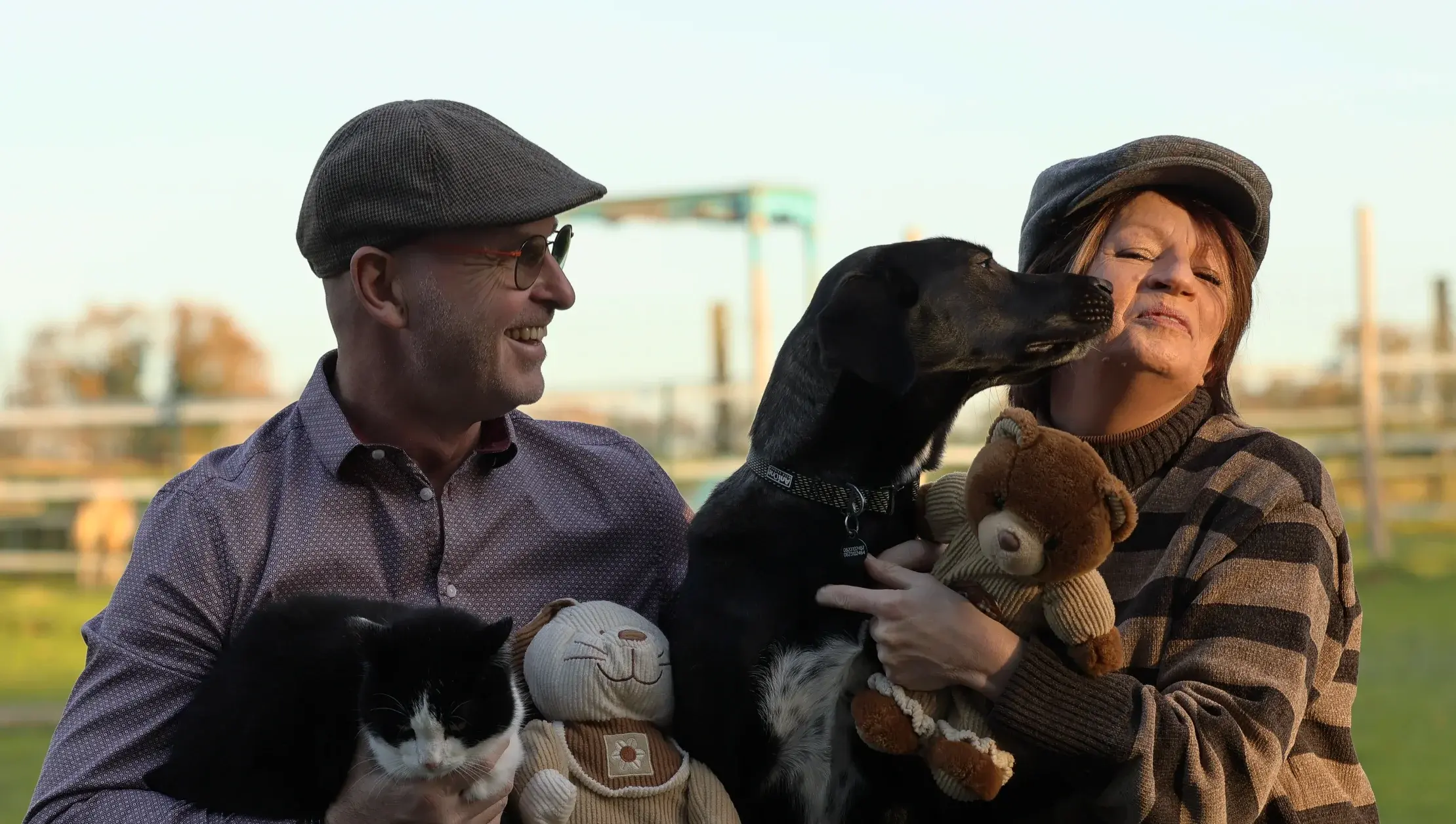 Couple en casquettes embrassé par leur chien, photographié par Com’Lou